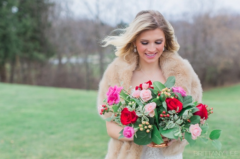 winter wedding inspiration with fur shrug and red flowers