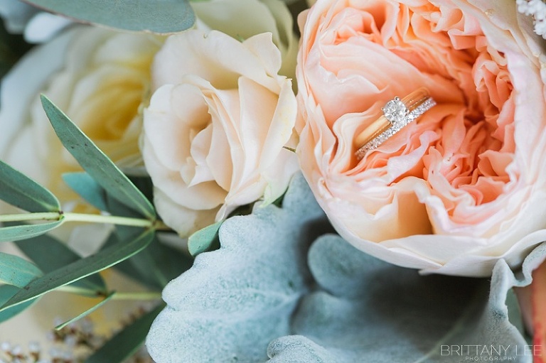Gold solitaire engagement ring in bridal bouquet