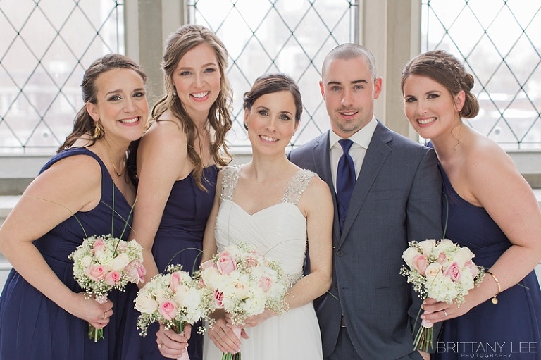 Bridal party in navy with blush bouquets with roses and babysbreath