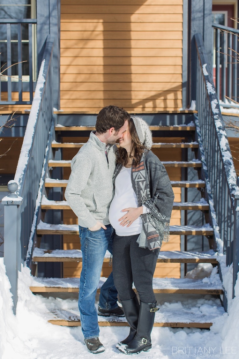 Mont Tremblant Winter Maternity Photos - couple kissing outside ski lodge