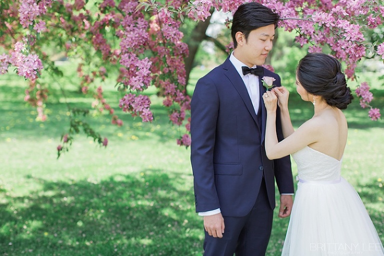 Bride putting on groom's boutonniere