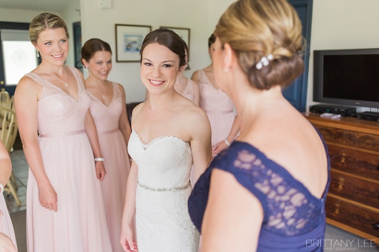 Bridesmaids helping bride into her wedding dress at Strathmere Ottawa