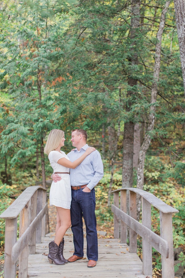 Wakefield fall engagement photos  - couple standing on little wooden bridge