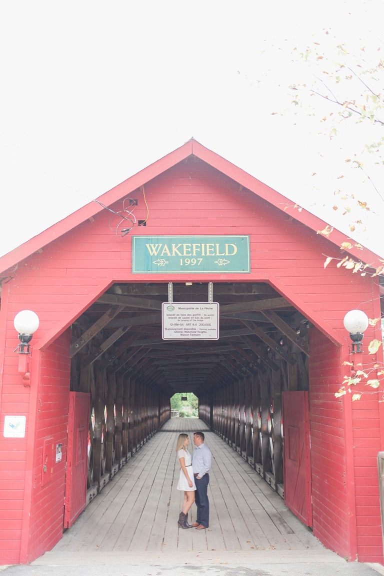 Wakefield fall engagement photos  - couple underneath red wooden covered bridge