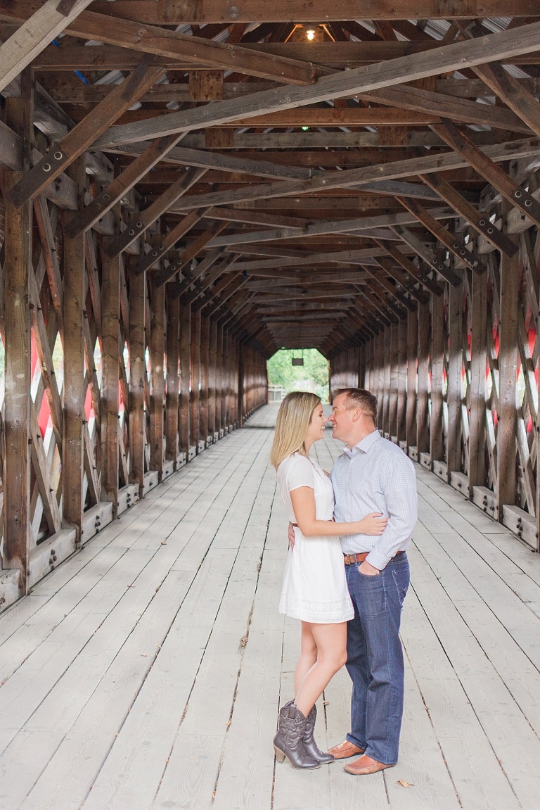 Wakefield fall engagement photos  - couple underneath red wooden covered bridge