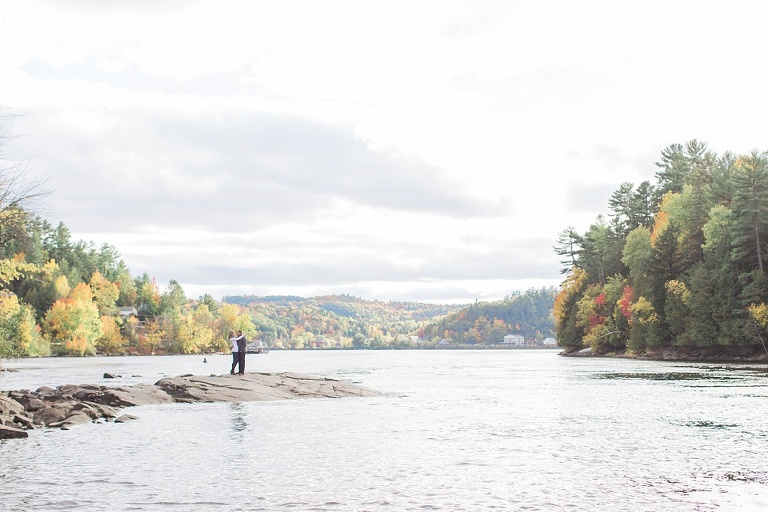 Wakefield fall engagement photos  - couple standing on rocks  along the river