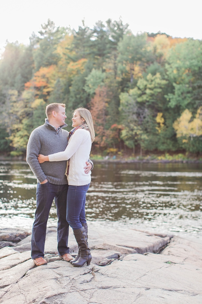 Wakefield fall engagement photos  - couple standing on rocks  along the river