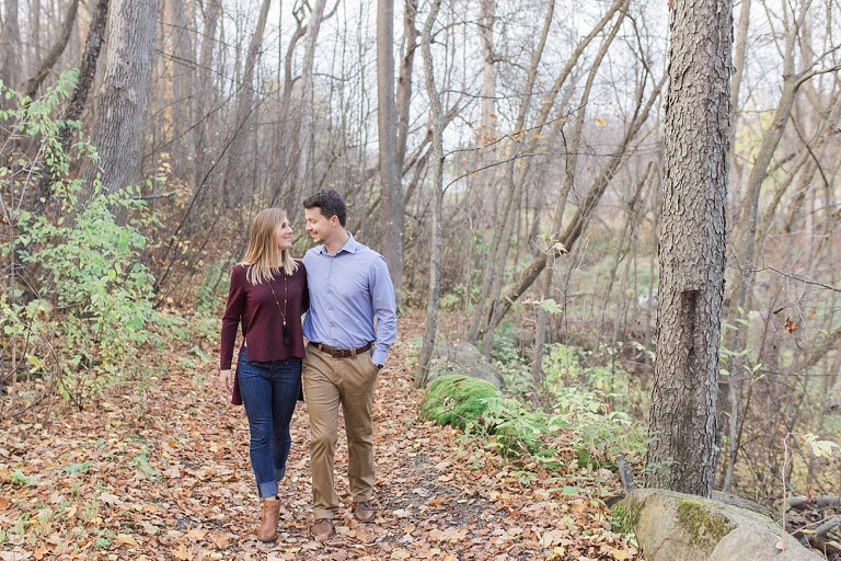 Stonebridge Trail Fall Engagement Session - Bride and Groom on walking along pathway with fallen leaves